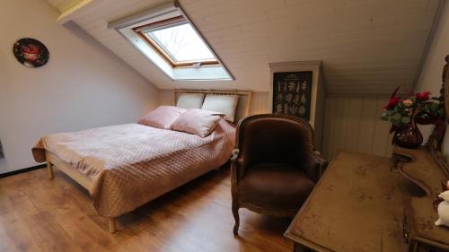 a bedroom with a bed and a window and a chair at Gite de l'oseraie 