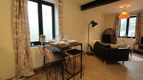 a living room with a table and chairs and a couch at Gite de l'oseraie 