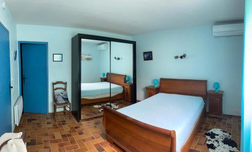 une chambre avec un lit et un miroir dans l'établissement Casa Paulette, à Cavalaire-sur-Mer
