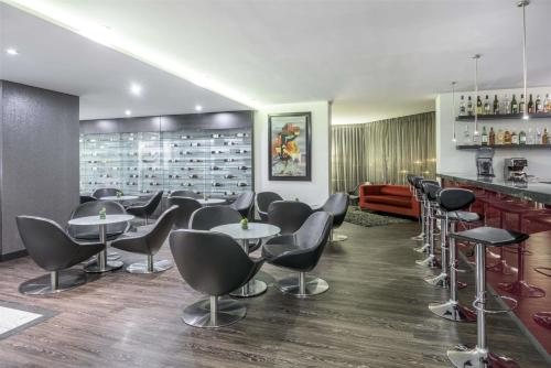 a bar with chairs and tables in a restaurant at NH Bogota Urban 26 Royal in Bogotá
