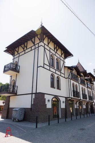 a large white building with a balcony on a street at Апартаменти в центрі Шаян in Shaian