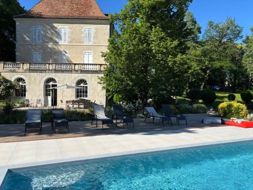 une maison avec piscine devant un immeuble dans l'établissement Château de Foussal, à Issigeac