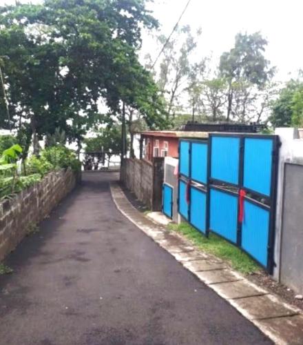 an empty street with a fence and a building at Chaleureuse maison située a 1 minute de la plage in Le Morne