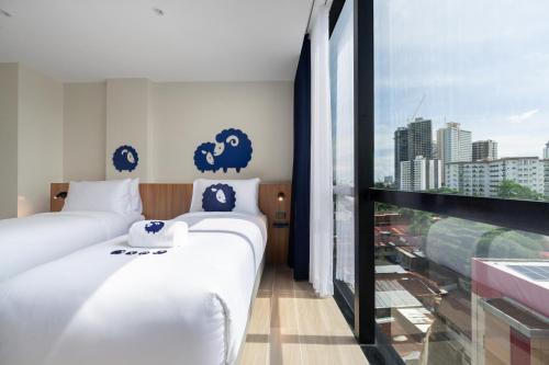 a hotel room with two beds and a window at Kokotel Cebu Adira in Cebu City