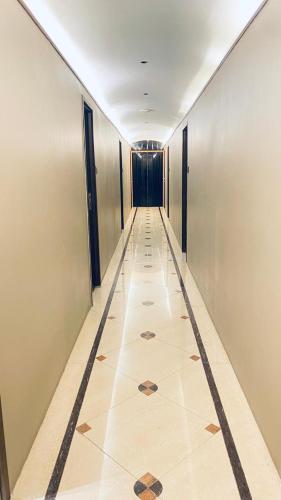 a long hallway with a tile floor in a building at Palm Breeze Hotel - Colaba in Mumbai