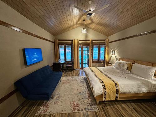 a bedroom with a bed and a blue couch at Dream Nest Resorts in Skardu