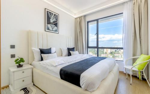 a bedroom with a large bed and a window at Panorama Suites in Nairobi with Swimmingpool,Wifi in Nairobi