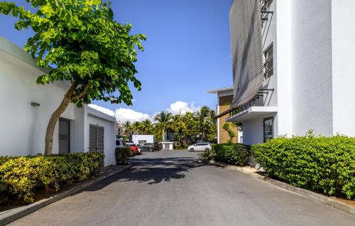 a street in front of a building with a car at Cap Ouest by Horizon Holidays in Flic-en-Flac