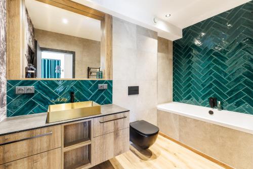 Un baño con lavabo, bañera y espejo. en DearDeer apartmán s terasou, en Železná Ruda