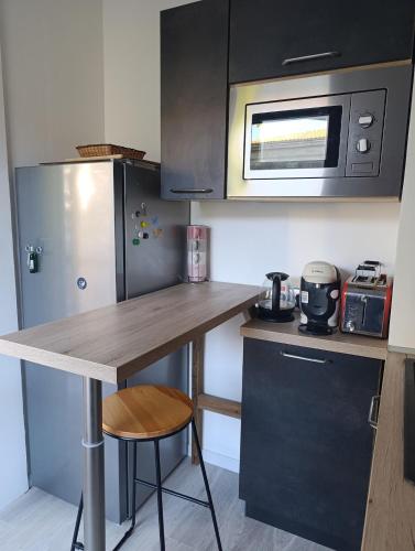 une petite cuisine avec un comptoir et un micro-ondes dans l'établissement Bordeaux appartement avec belles prestations - balcon - parking, à Bordeaux