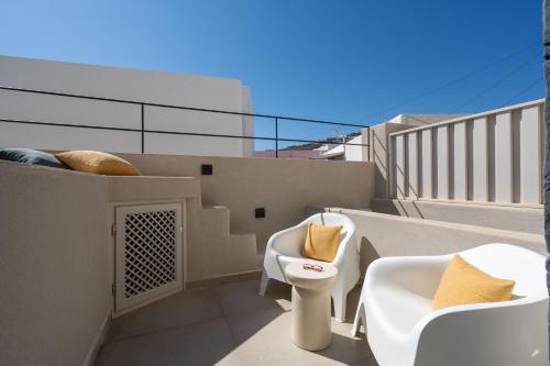 a balcony with two chairs and a toilet on a balcony at White Orchid Boutique Apartments in Vóthon