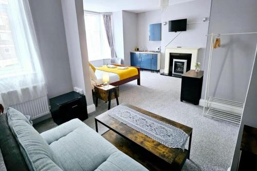 una sala de estar con un sofá y una cama en Seaside Escape 2-Bed maisonette Flat - Ev22kwh, en Southsea