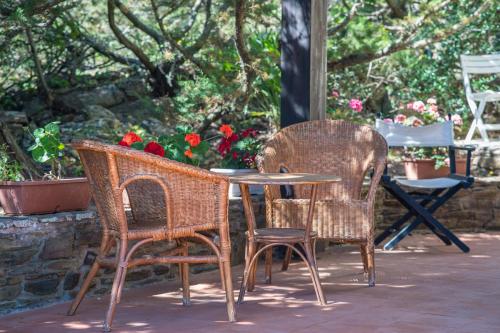 two wicker chairs and a table and two chairs at Casa Vacanze Sabina - Stintino in Stintino