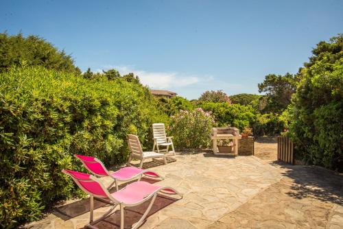 three chairs and a grill on a patio at Casa Vacanze Sabina - Stintino in Stintino