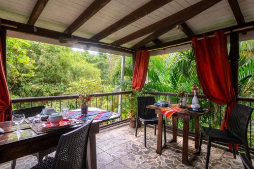 a patio with a table and chairs on a balcony at Hibiscus Valley Inn in Marigot
