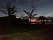 a view of a beach with palm trees at night at Minshuku Myojoso in Yoron