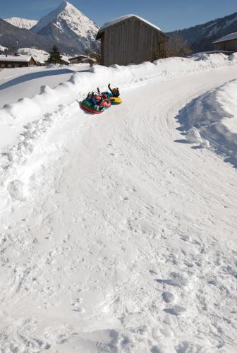 a group of people riding down a snow covered road at Kanis Appartements in Schoppernau