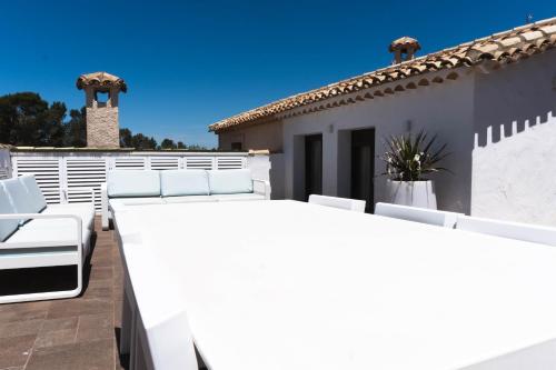 a patio with white chairs and a house at Casa La Muralla de Alarcón in Alarcón
