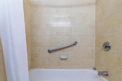 a bathroom with a shower with a white tub at Motel 6 Dallas TX Downtown in Dallas