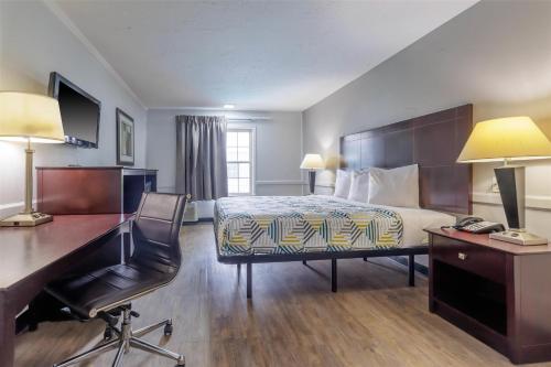 a hotel room with a bed and a desk and a desk at Motel 6 Dallas TX Downtown in Dallas