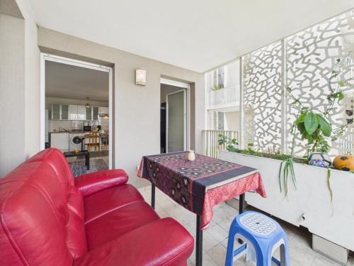 un salon avec un canapé rouge et une table dans l'établissement CosyHome in Paris, gare et terrasse, à Gennevilliers