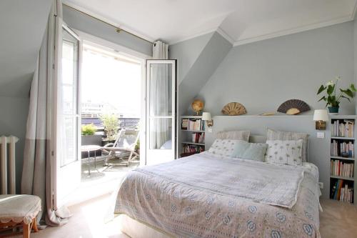 une chambre avec un lit et une grande fenêtre dans l'établissement Stunning flat with terrasse - Trocadéro, à Paris