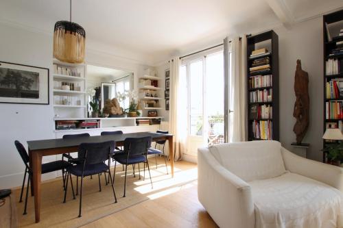un salon avec une table, des chaises et un canapé dans l'établissement Stunning flat with terrasse - Trocadéro, à Paris