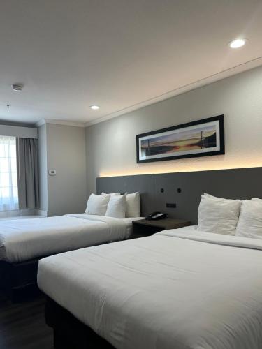 a hotel room with two beds and a picture on the wall at Quality Inn & Suites in Santa Rosa