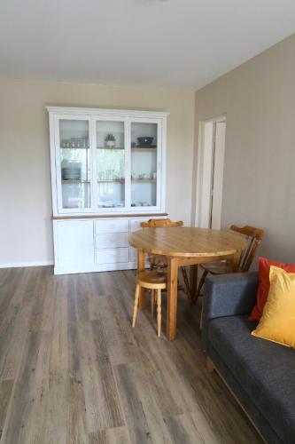 a living room with a table and a couch at Le refuge Marin - Mer, Piscine, Vélo & Loisirs à 2 pas in Cabourg