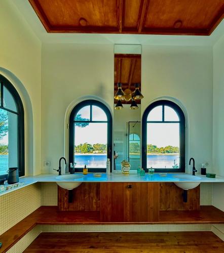 une salle de bain avec deux lavabos et deux fenêtres dans l'établissement Villa Art Deco luxe vue imprenable sur la lac d Hossegor Clim, à Hossegor