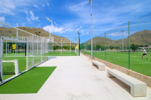 a soccer field with two benches and a goal at Aparthotel Duva & Spa in Port de Pollensa
