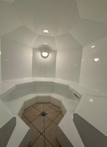 Cette chambre blanche est dotée d'un plafond lumineux. dans l'établissement Appartement front de mer, 80M2 (3P), Piscine & Mer, à Cannes