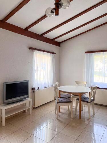 a living room with a table and a tv at Aabach Stay in Niederlenz