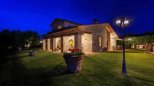 a stone house with a street light in a yard at LE MACINE 6, Emma Villas in Castel del Piano