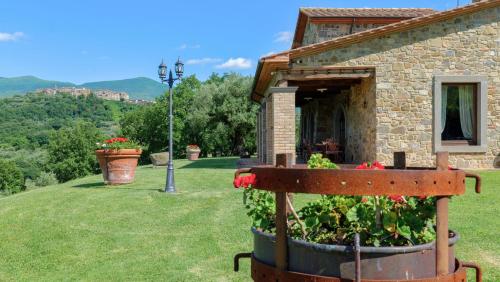a garden in front of a building with flowers in a barrel at LE MACINE 6, Emma Villas in Castel del Piano