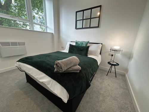 a bedroom with a bed with green sheets and pillows at Hull NEW Central Apartment 15 UNITS AVAILABLE in Hull
