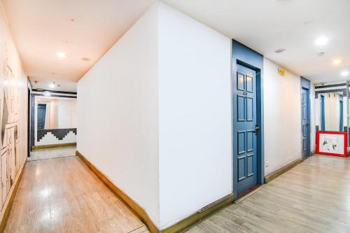 an empty hallway with a blue door and wooden floors at FabHotel Suncitel - Nr Netaji Subhash Chandra Bose International Airport in Kolkata