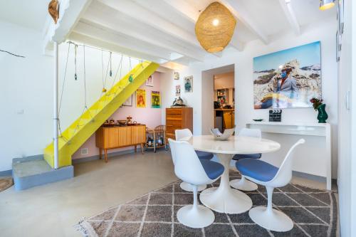 une pièce avec une table, des chaises et un escalier dans l'établissement Maison de charme au coeur des Goudes 5 pers, à Marseille