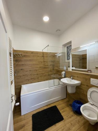 a bathroom with a tub and a toilet and a sink at Princo Apartments in Hunedoara