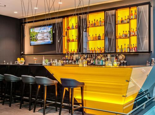 a yellow bar in a restaurant with stools at Hotel Indigo Warsaw Nowy Świat by IHG in Warsaw