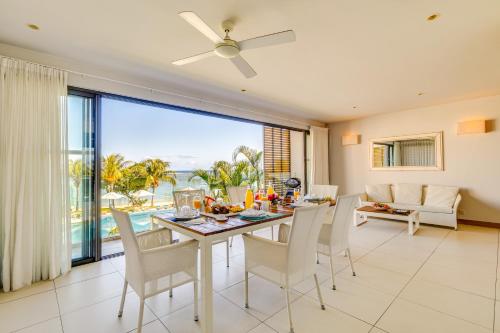 a dining room with a table and chairs with a view of the ocean at Cap Ouest by Horizon Holidays in Flic-en-Flac