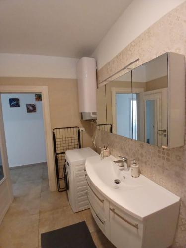 a bathroom with a white sink and a mirror at Omega Apartments in Premantura