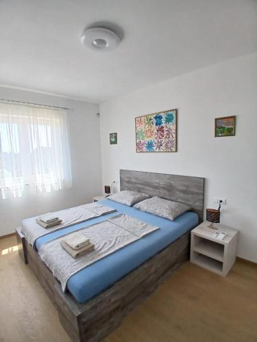 a bedroom with a large bed in a white room at Omega Apartments in Premantura