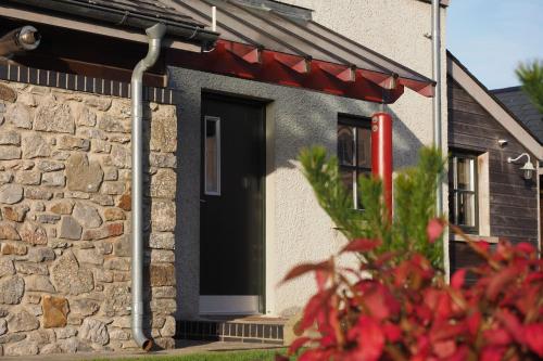 een huis met een zwarte deur en een stenen muur bij Beili in Saint Florence