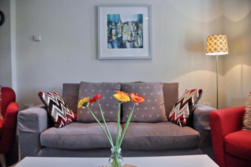 een woonkamer met een bank en een tafel met bloemen bij Beili in Saint Florence