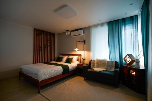 a bedroom with a bed and a chair at 종로 동대문 3룸 아파트 in Seoul