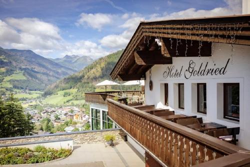 a building with a balcony with a view of a valley at Hotel Goldried in Matrei in Osttirol