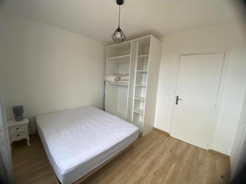 une chambre avec un lit blanc et un placard dans l'établissement Bel appartement 2 chambres, proche centre ville - parking, à Vals-près-le-Puy