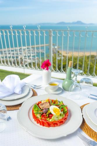 a table with a plate of food on a table with the ocean at La Demeure in Sidi Bou Saïd