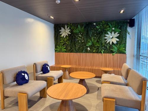 a waiting room with tables and chairs and flowers on the wall at Kokotel Cebu Adira in Cebu City